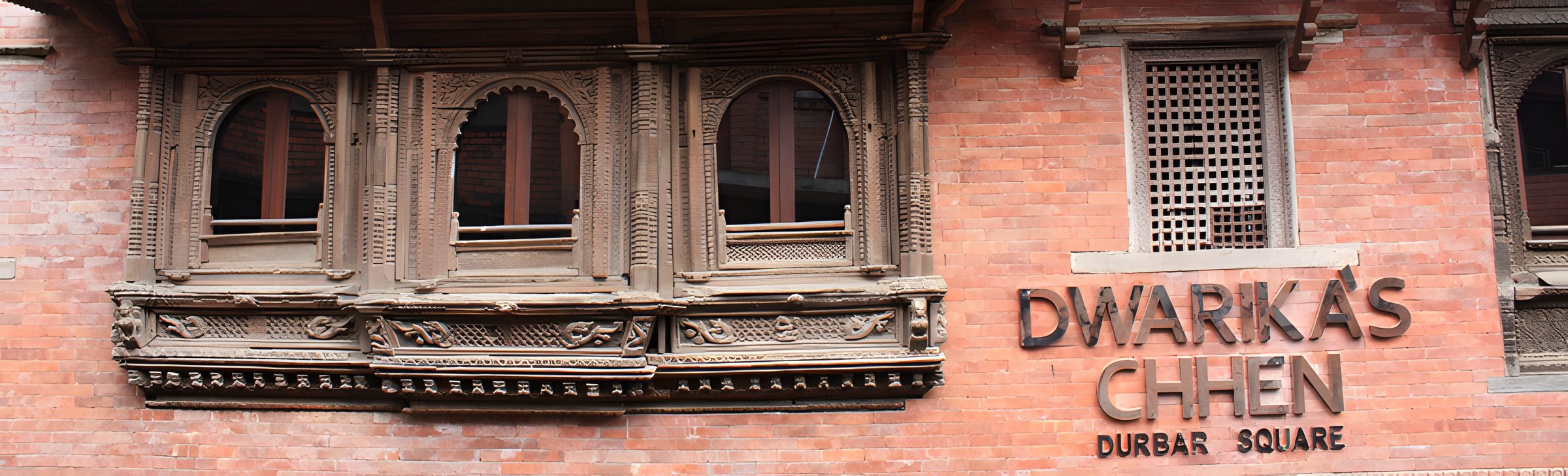 Carved Newari windows and the Dwarika's Chhen sign on the facade