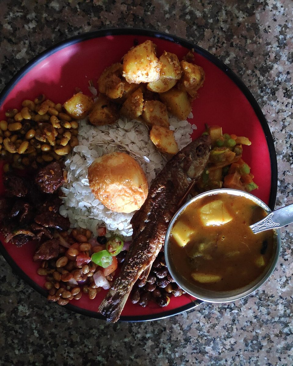 A Newari set: beaten rice, egg, spiced potatoes, beans and pickles