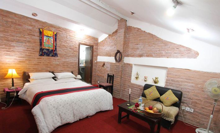 Standard room with red carpet and thangka
